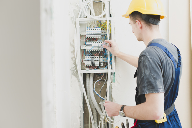 Electrician Working with Switchboard